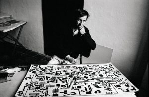 Alighiero Boetti davanti alla Storia naturale della moltiplicazione nel suo studio, 1976 - foto Gianfranco Gorgoni